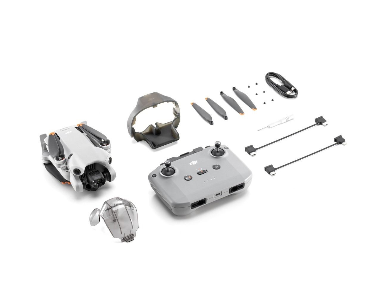 DJI drone set with controller, propellers, cables, and accessories on white background.