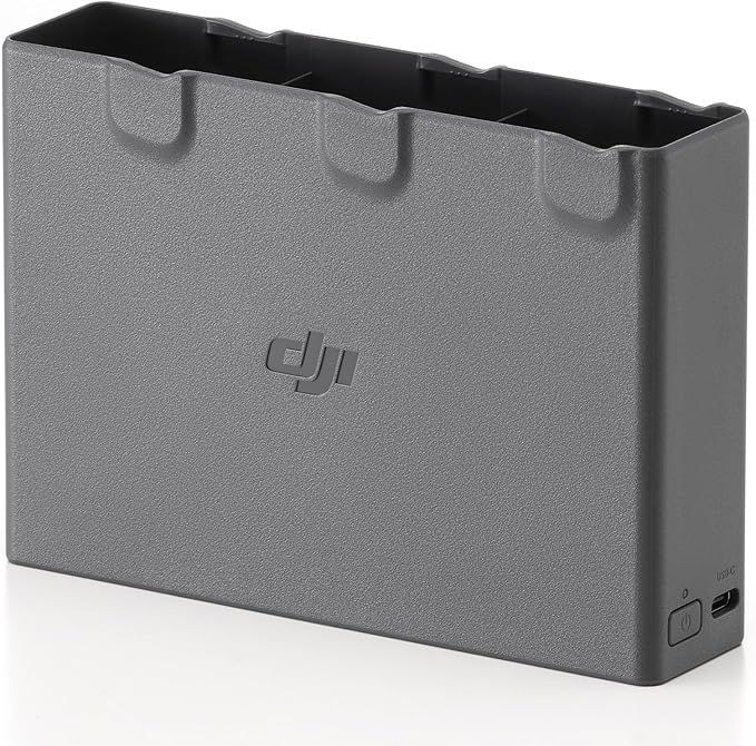 Close-up view of a grey charging hub for DJI batteries with three slots and textured surface.