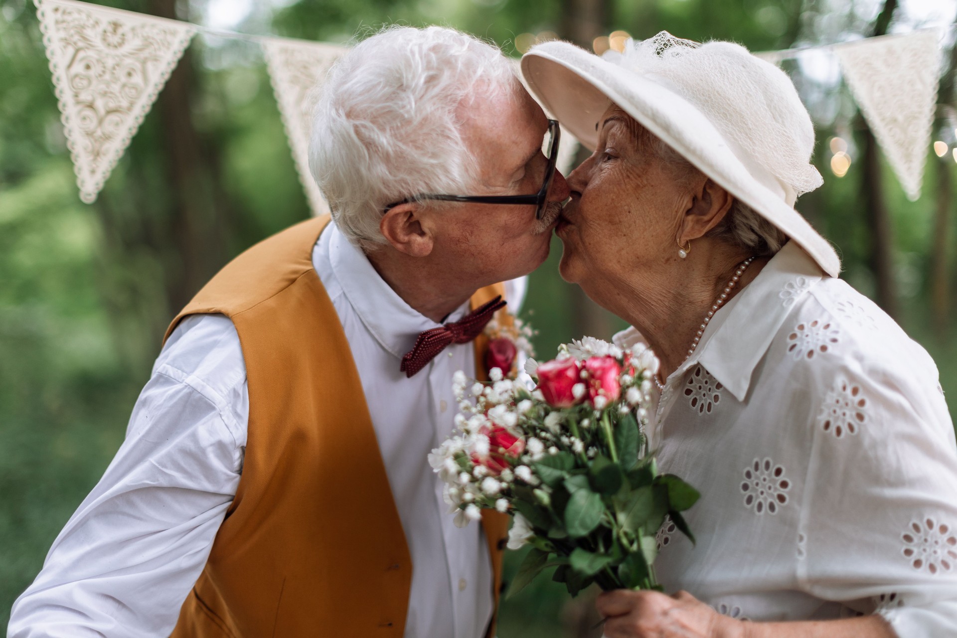 Senior couple having marriage, kissing in nature during summer day.
