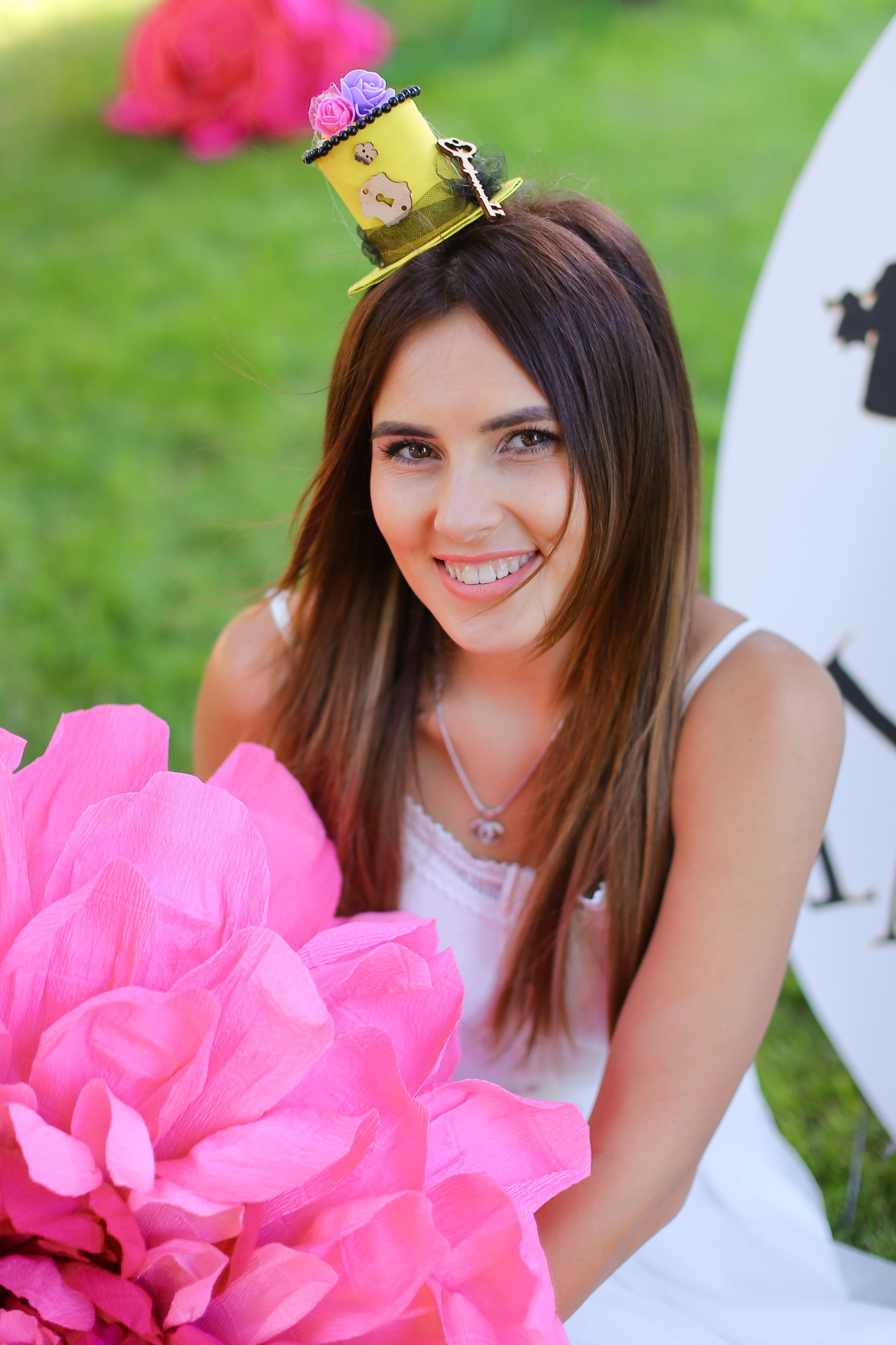 Young european girl sitting at decorated place for children near pink flower